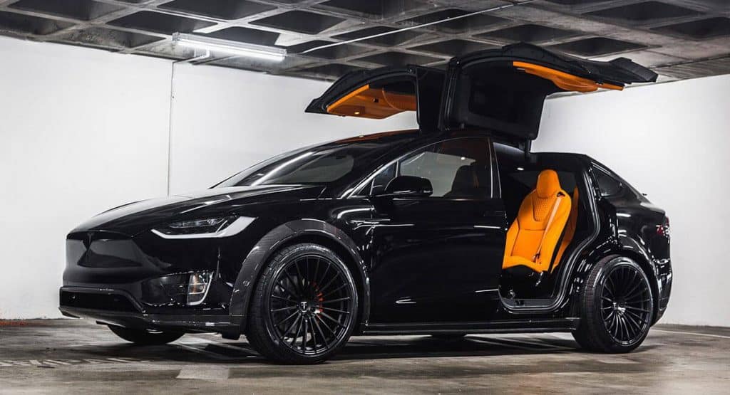 A black Tesla with bright orange custom interior.