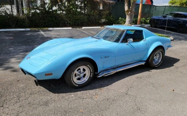 The classic baby blue Corvette parked in a parking lot.