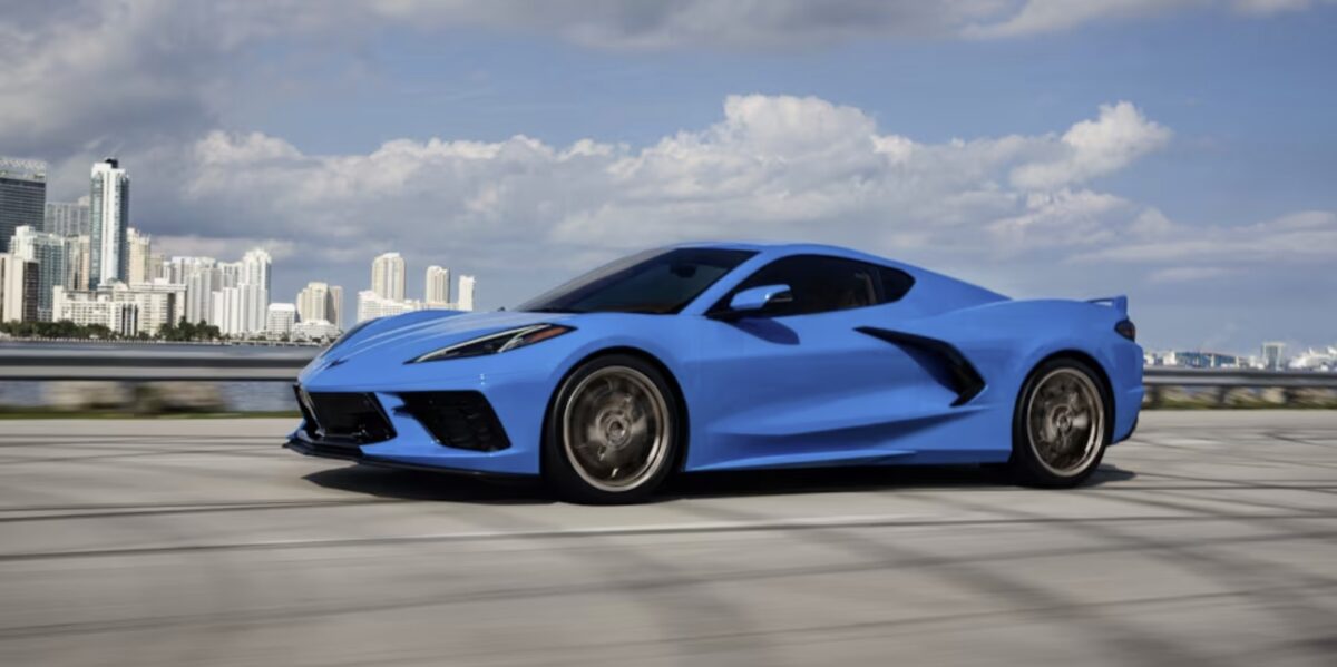 A blue Corvette Stingray parked on a paved road.