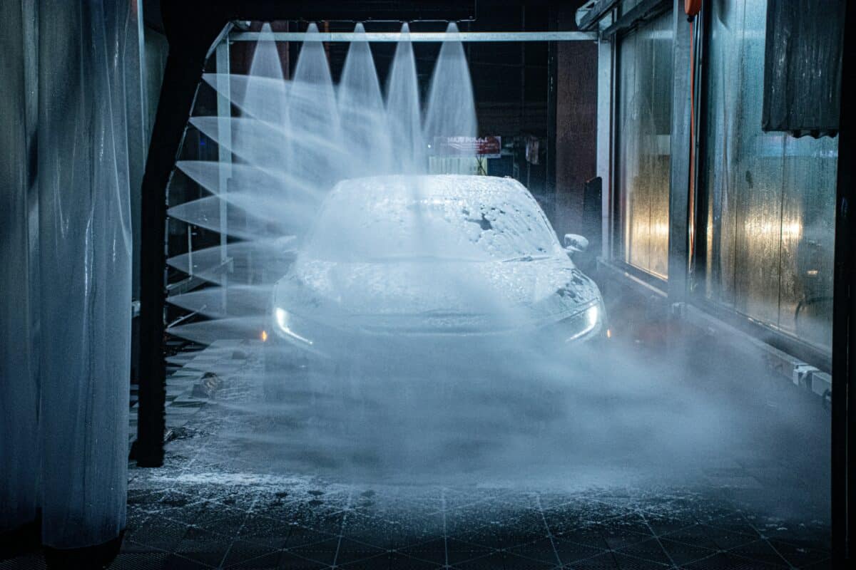 A blue Honda Civic is going through a car wash.