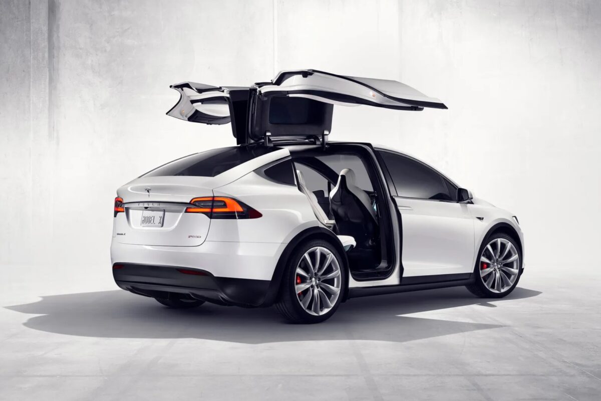 a white tesla model x with its doors open