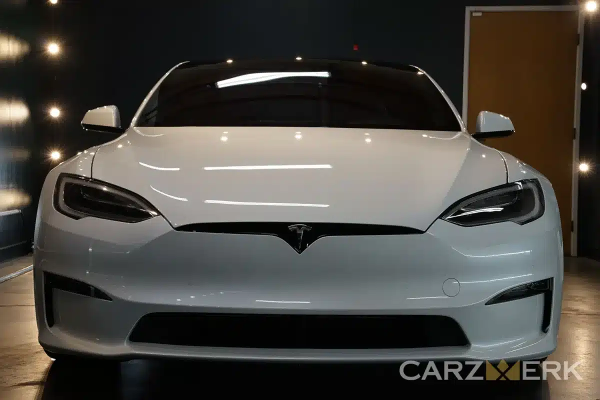 A white Tesla parked inside the Carzwerk garage as it undergoes Tesla detailing.