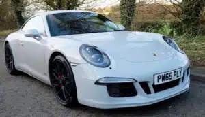 A grigio campovolo porsche in europe is parked outside. 