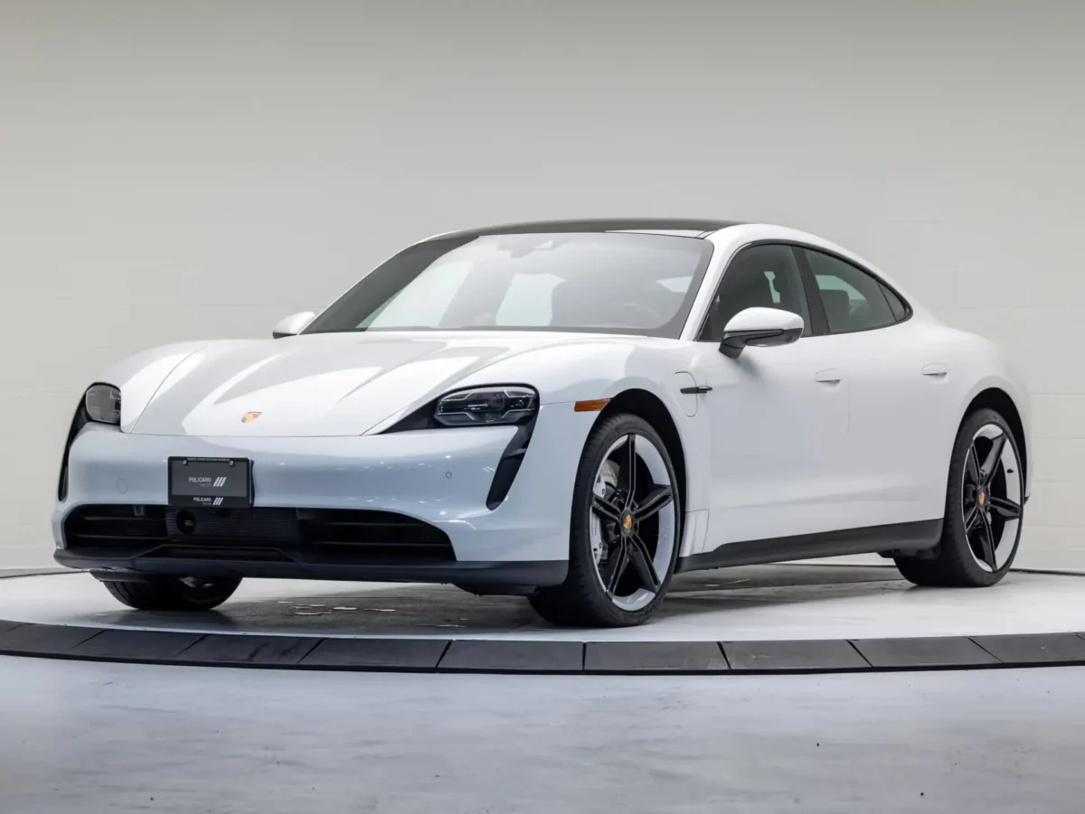 A Chalk White Porsche parked on a cement floor with a white background.