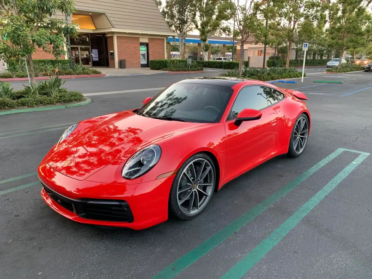 Guards Red Porsche exterior colors on full display on a Porsche outside on a bright day.