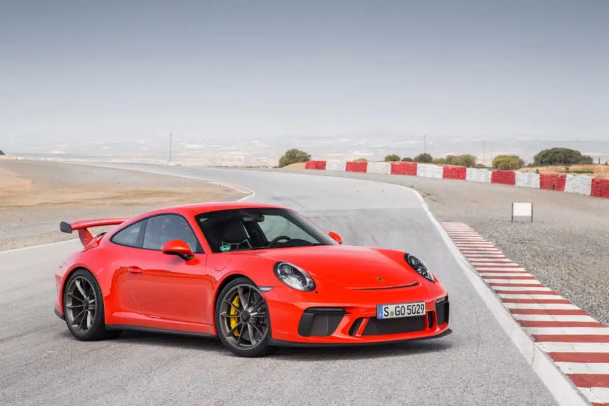 A Lava Orange Porsche exterior colors on full display on a Porsche outside on a bright day.