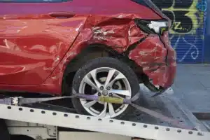 A red car that has been in an accident. The back end is in need of Bay Area dent repair services.