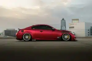 A red JDM car in California is parked under a grey sky.