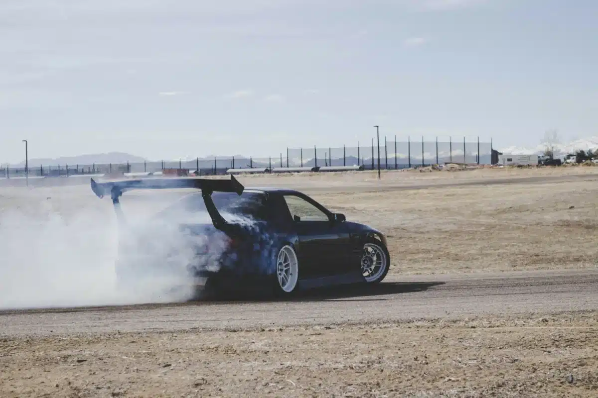 A car is going fast on dusty race tracks in the Bay Area.