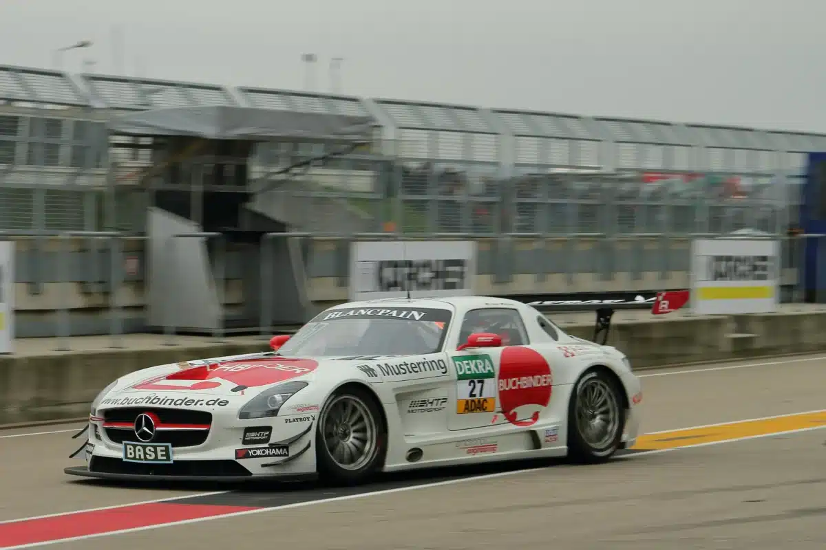 A white and red race car on a race track in the Bay Area during a cloudy day.