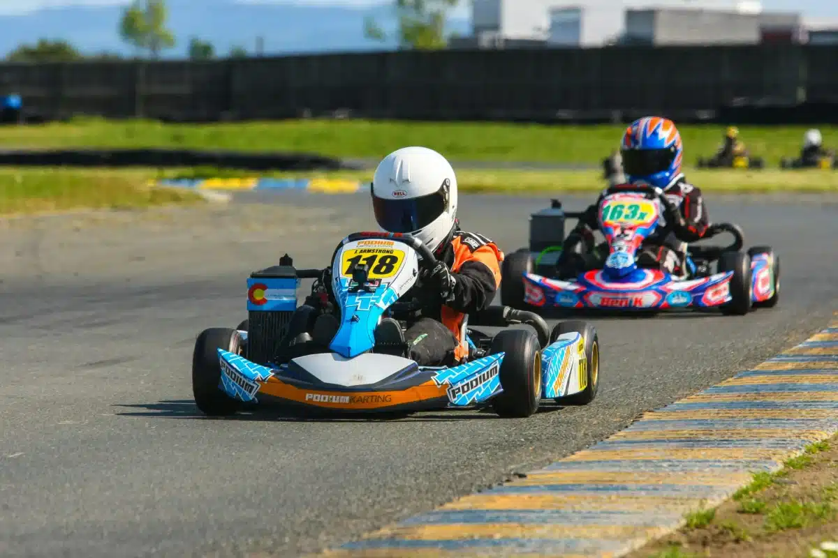 A go karting and race track in the Bay Area is pictured here, with two participants driving go karts with helmets on.