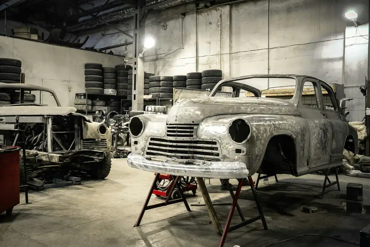 A vintage car on a hoist is pictured inside a garage. Next step is to choose what to do when your car is in the shop.