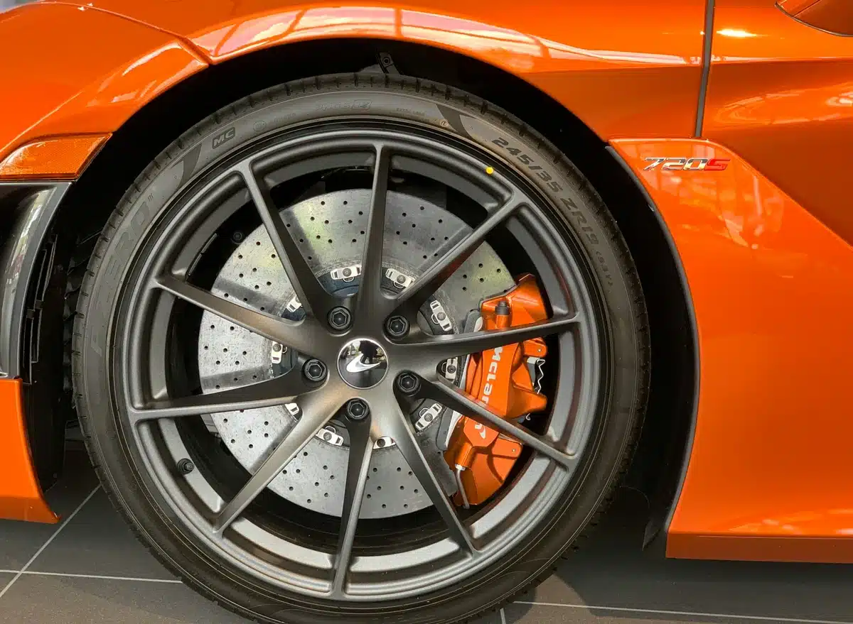 Orange brake caliper paint on an orange car with black hubcaps.