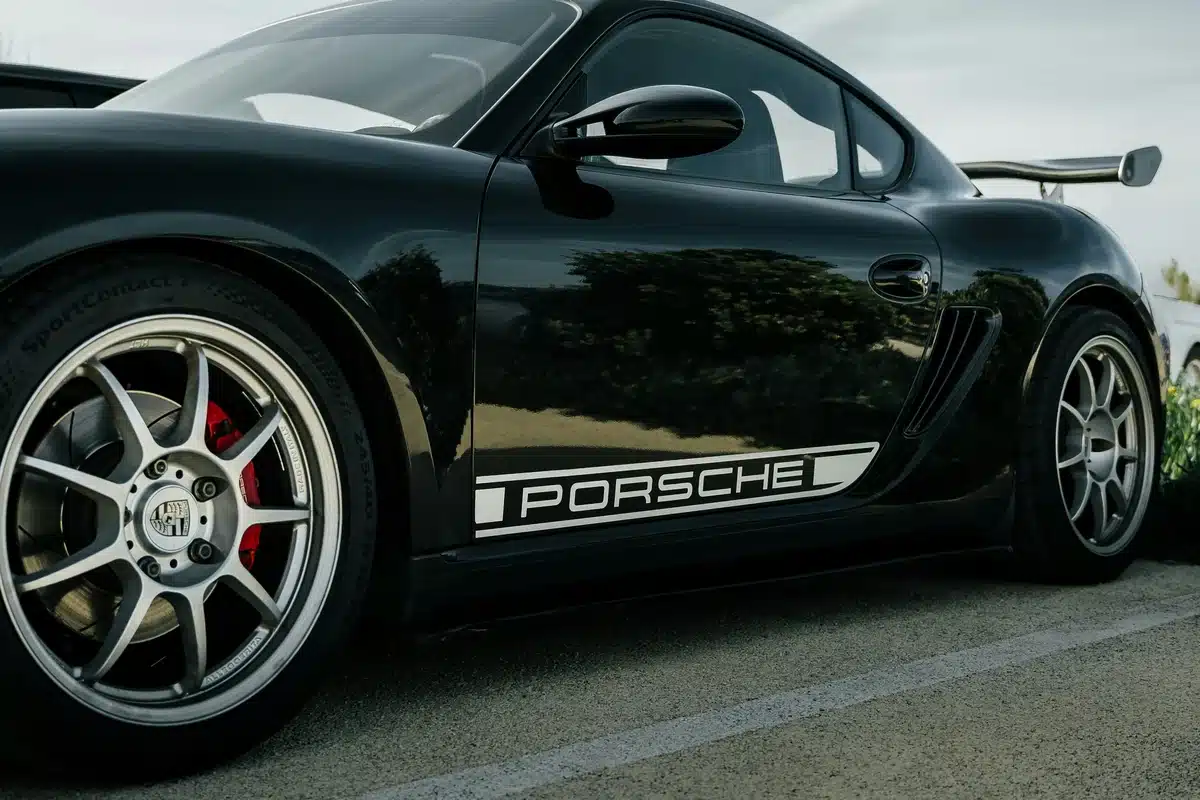 A black Porsche with red brake caliper paint.