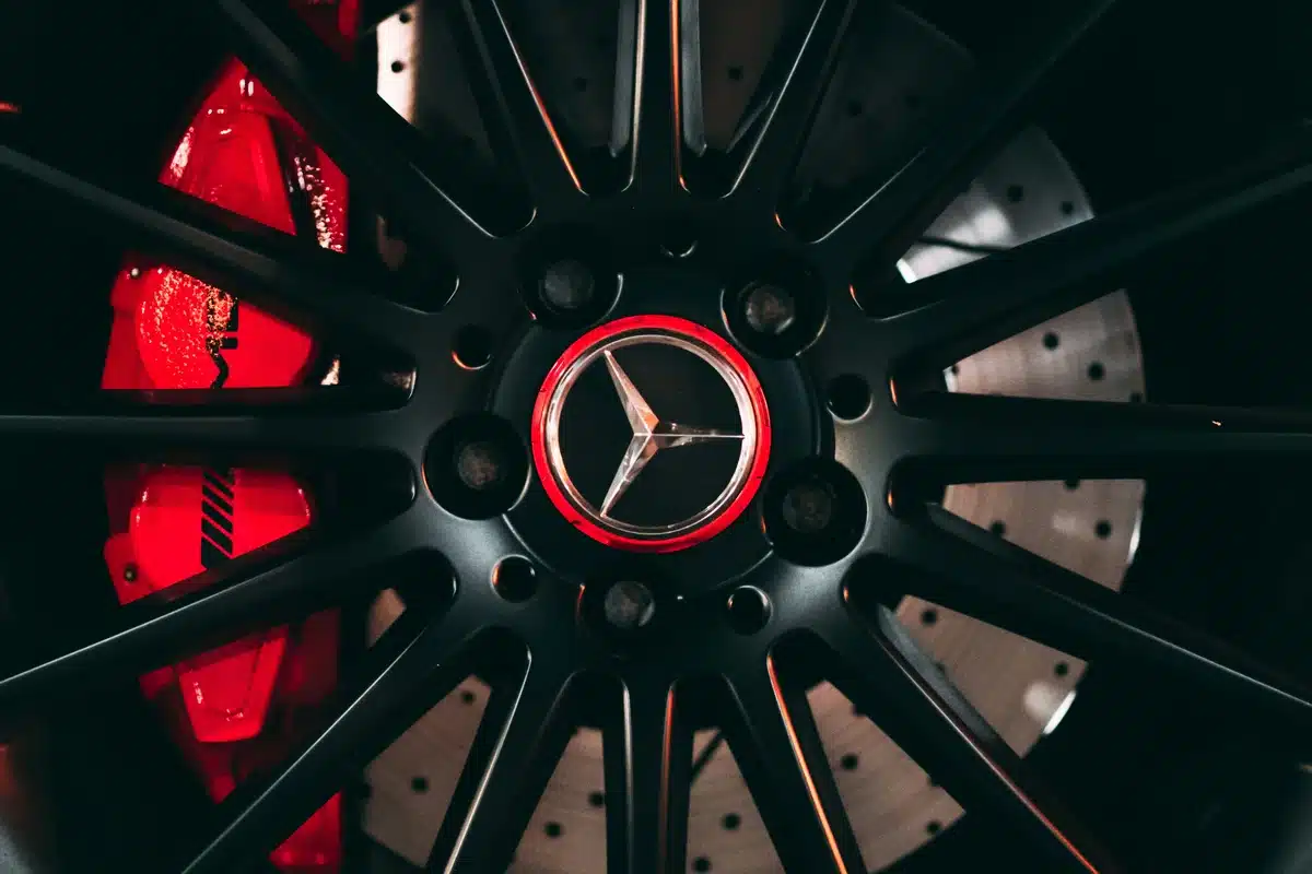 Red brake caliper paint on a Mercedes, zoomed in on a matte black hub cap.