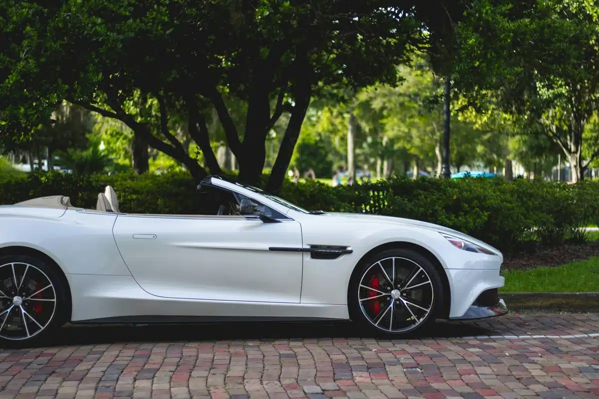 A white convertible Aston Martin with ceramic coatings and PPF is parked on a brick driveway.