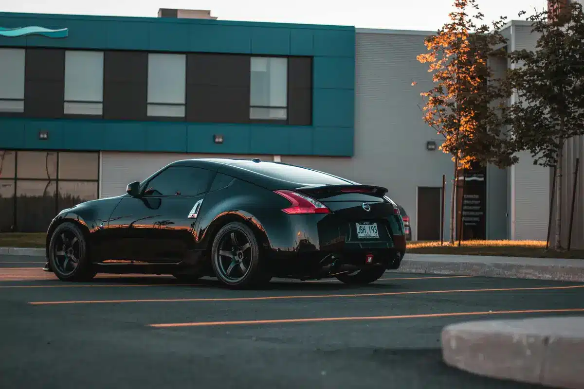 A black car with tinted windows is parked on a street.