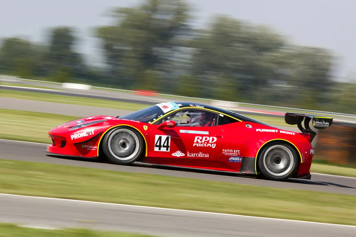 A red stock racing car driving on a track.