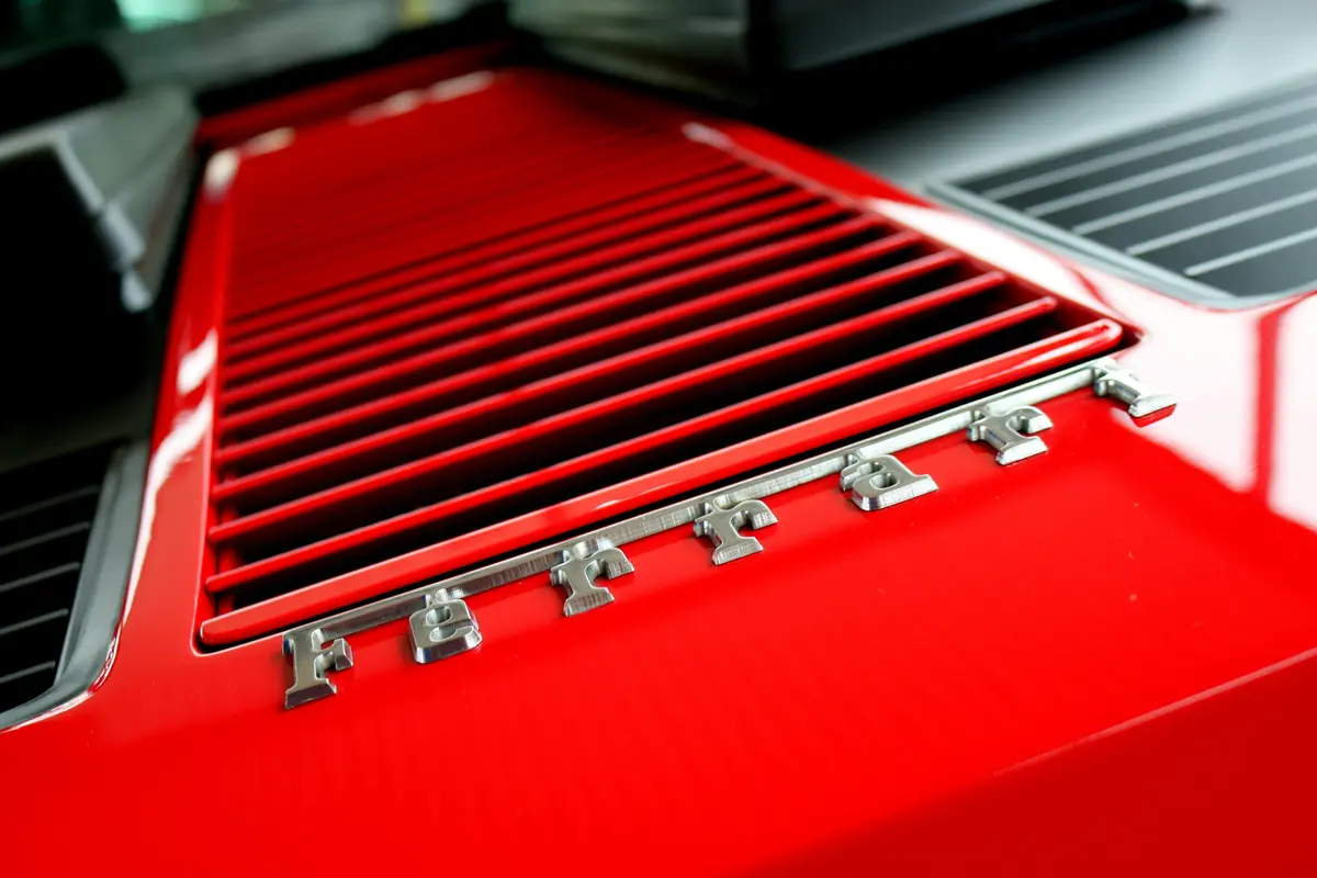 A Ferrari logo, photographed close up on a red exterior.