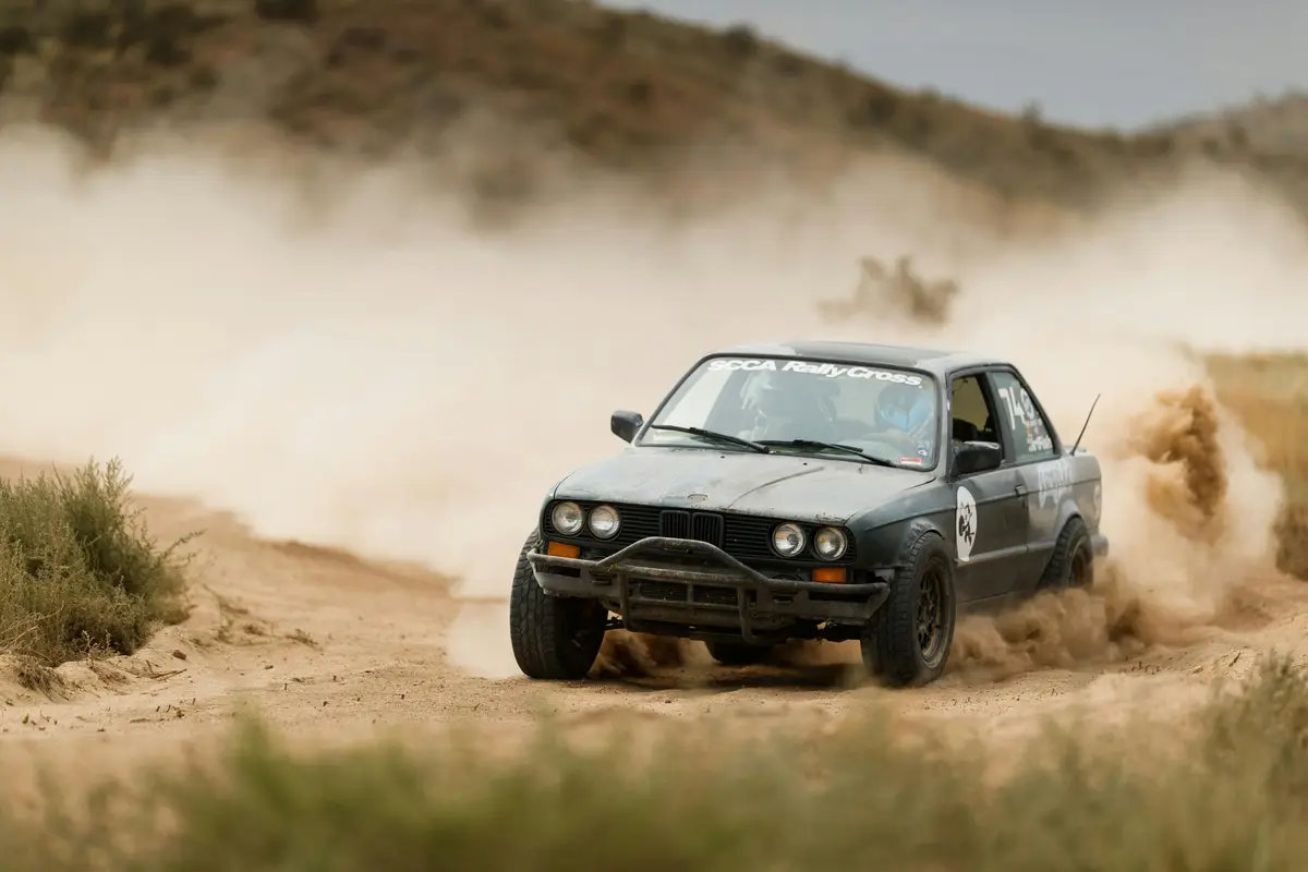 A dirt track race car getting dirty as it drives through rough terrain. 