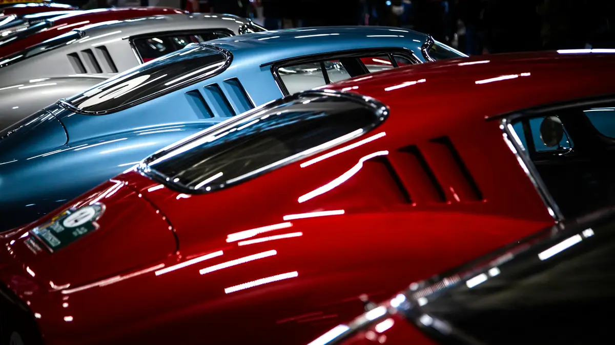 A lineup of new cars with new car prep and auto detailing near Palo Alto. From left to right, the Porches colors are silver, blue, red, and black.