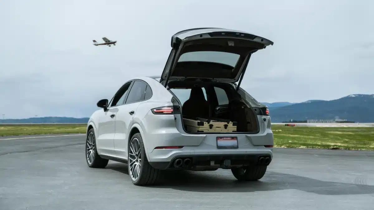 The back of white Porsche Cayenne with the trunk door open. 