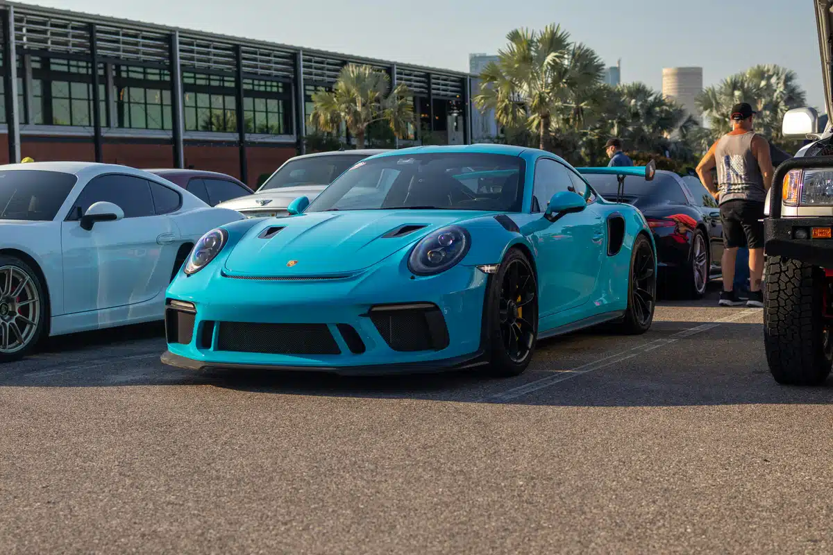 A light blue Porsche 911 protected for longer with PPF installed is parked in a parking lot. 