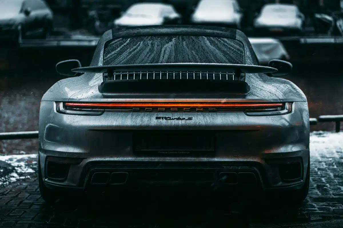 A Porsche 911 with PPF is parked in the rain.