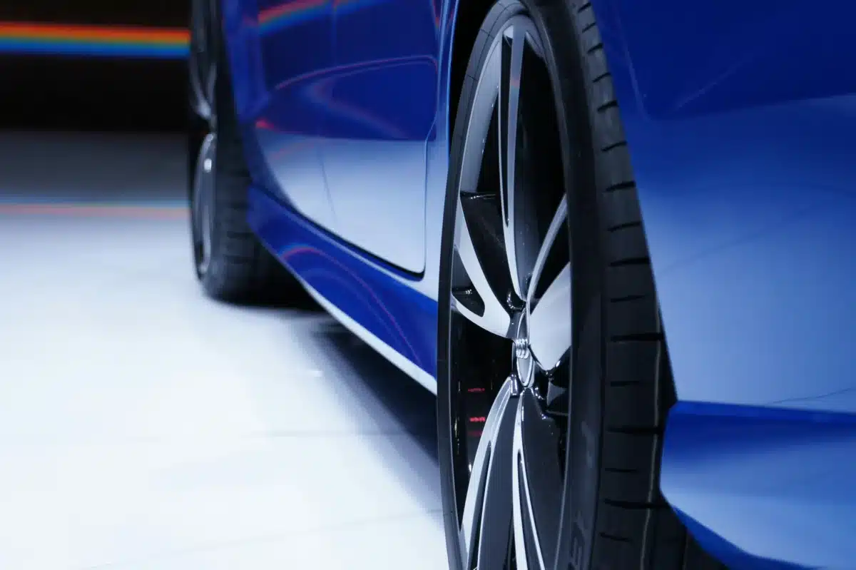 A close-up of a clean, newly detailed blue sports car wheel.