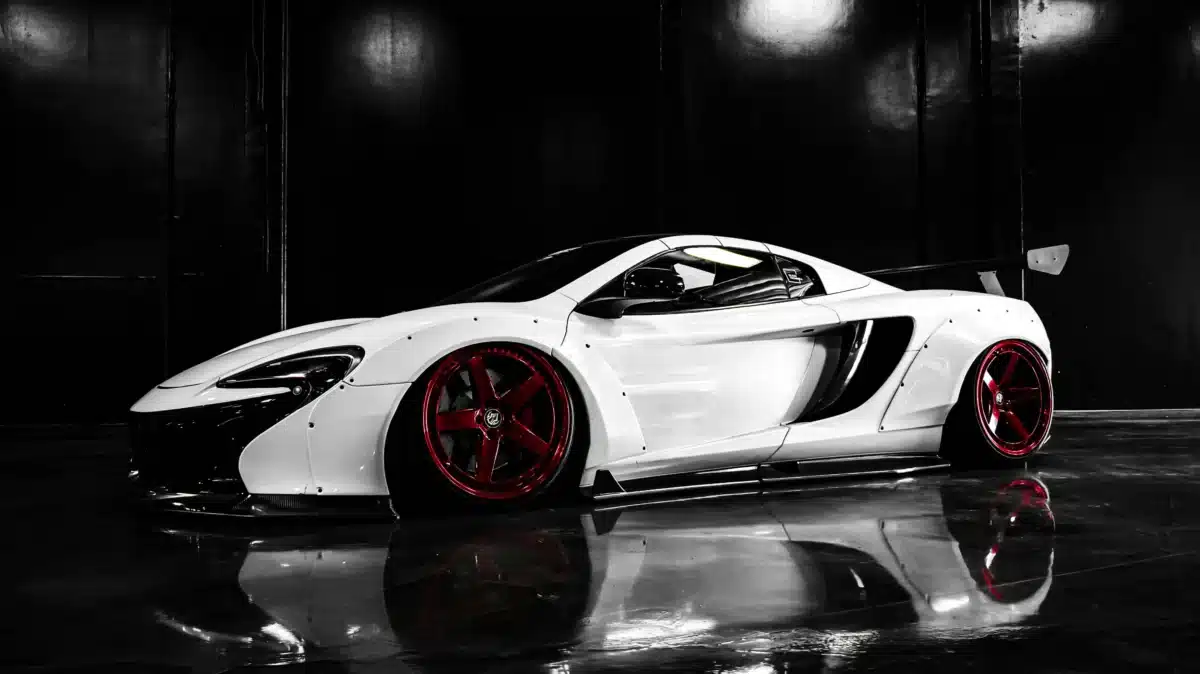 A white luxury sports car in a black, shiny garage after getting window tinting at Carzwerk.