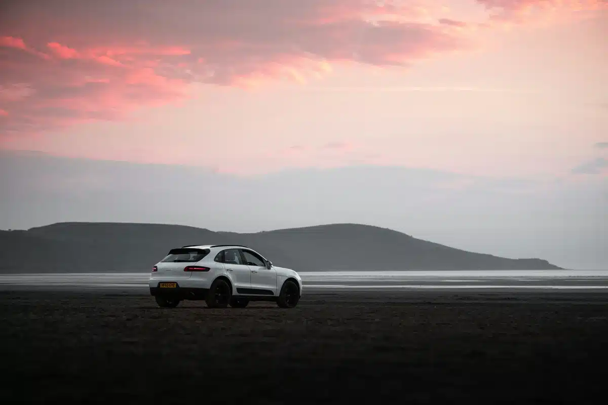 A Porsche Macan PPF job after the service is complete, parked in front of a Bay Area beach during sunset.