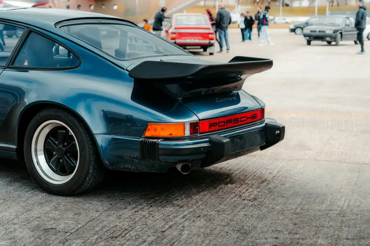 A vintage Porsche with dirt around the wheels and bottom of the body.